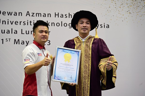 《马来西亚记录大全》营销与活动副总经理黄程运（左）将认证颁发给财务规划与顾问学院主席拿督林子浩。