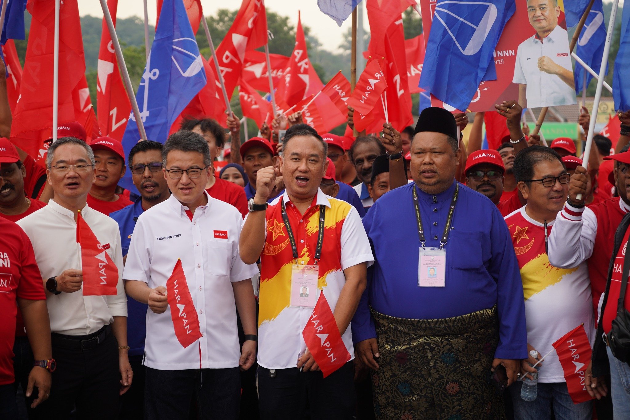 雷健强（中）前往提名前，与支持者在提名中心外喊口号。左2为行动党副秘书长刘镇东。