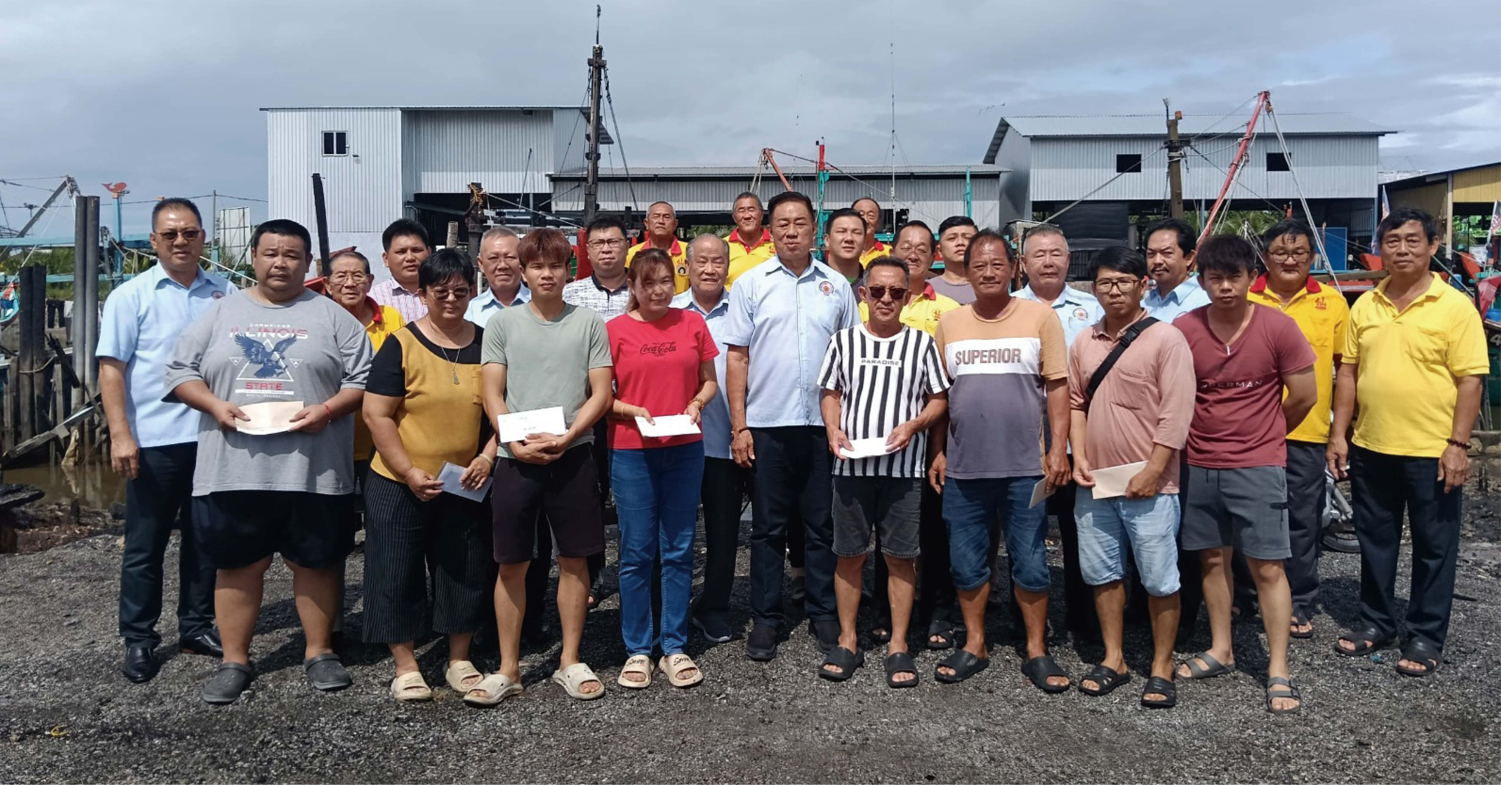 黄和鸣(前排中)、谢湖平(第二排右5)及谢民如(第二排左5)一同把援助金交给火灾灾黎。