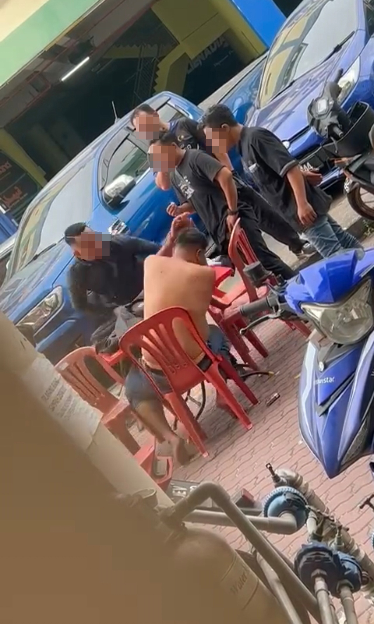 其中一名黑衣男掌掴和向赤裸上身者挥拳。