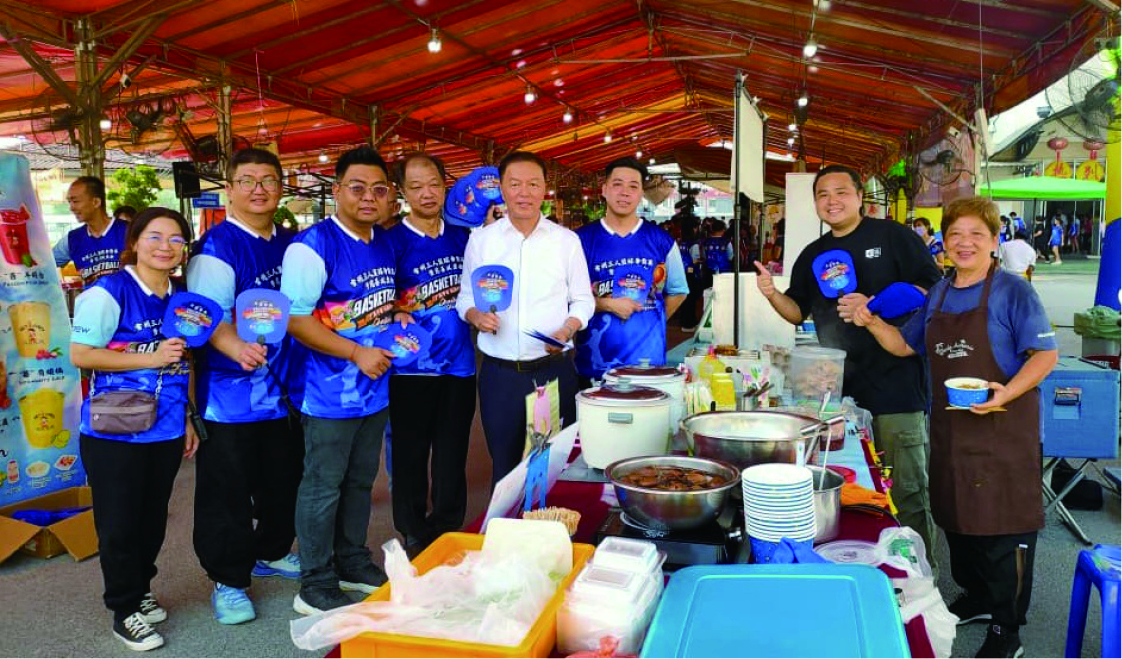 ■陈治年(左5)在要员陪同下到义卖摊位派发小扇子给各摊主。左起为刘美珍、杨志雄、吴汶豪、邹永光及邓锦胜(左6)。