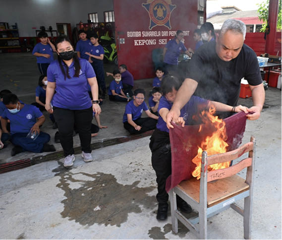 邓伟铭指导学生们实地学习灭火技巧,现场气氛热烈。